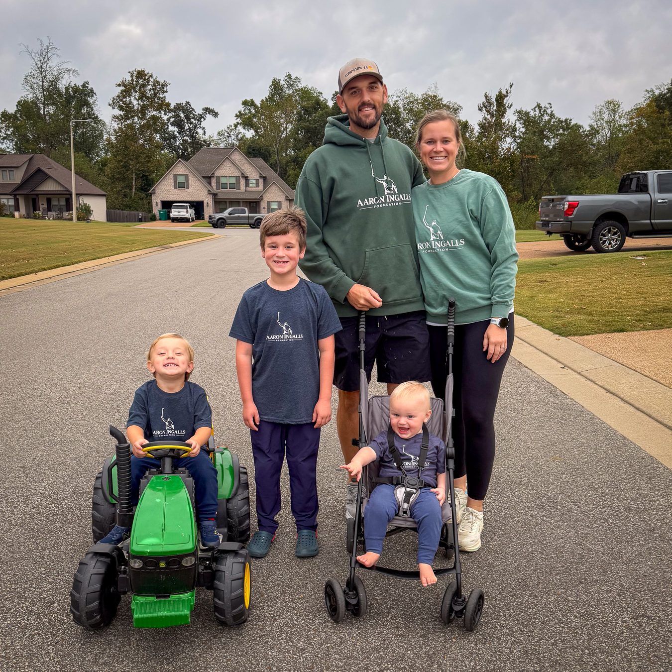 Family wearing green Aaron Ingalls Foundation hoodies and crewnecks and navy tees