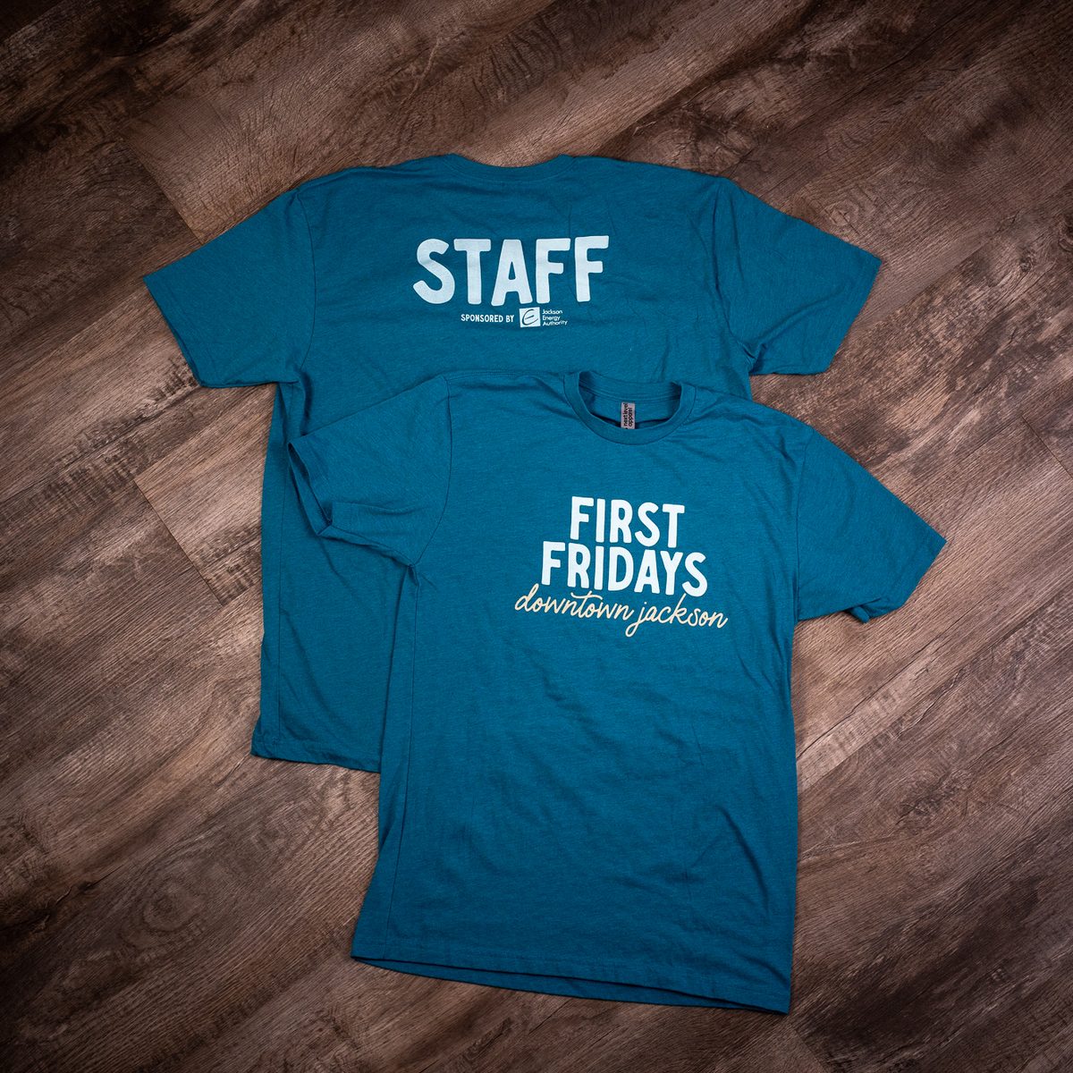 Teal First Fridays Downtown Jackson T-shirts with a STAFF back print sponsored by Jackson Energy Authority