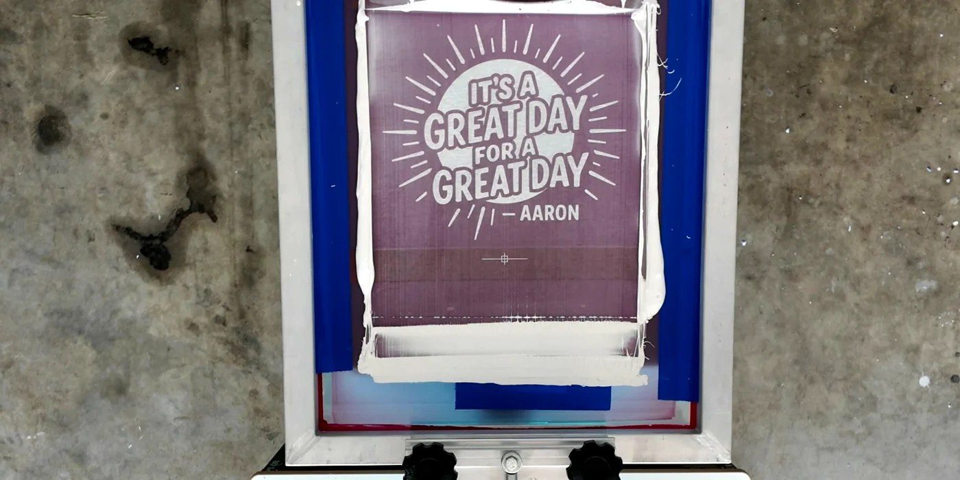 Overhead view of a freshly printed design under the screen on the press